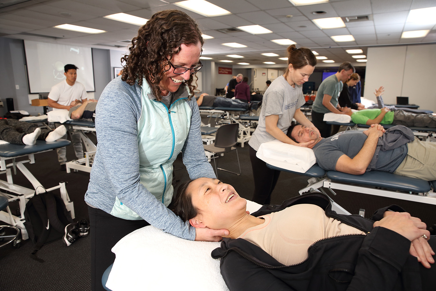 Students in a PT classroom, practicing hands-on skills with neck manipulation