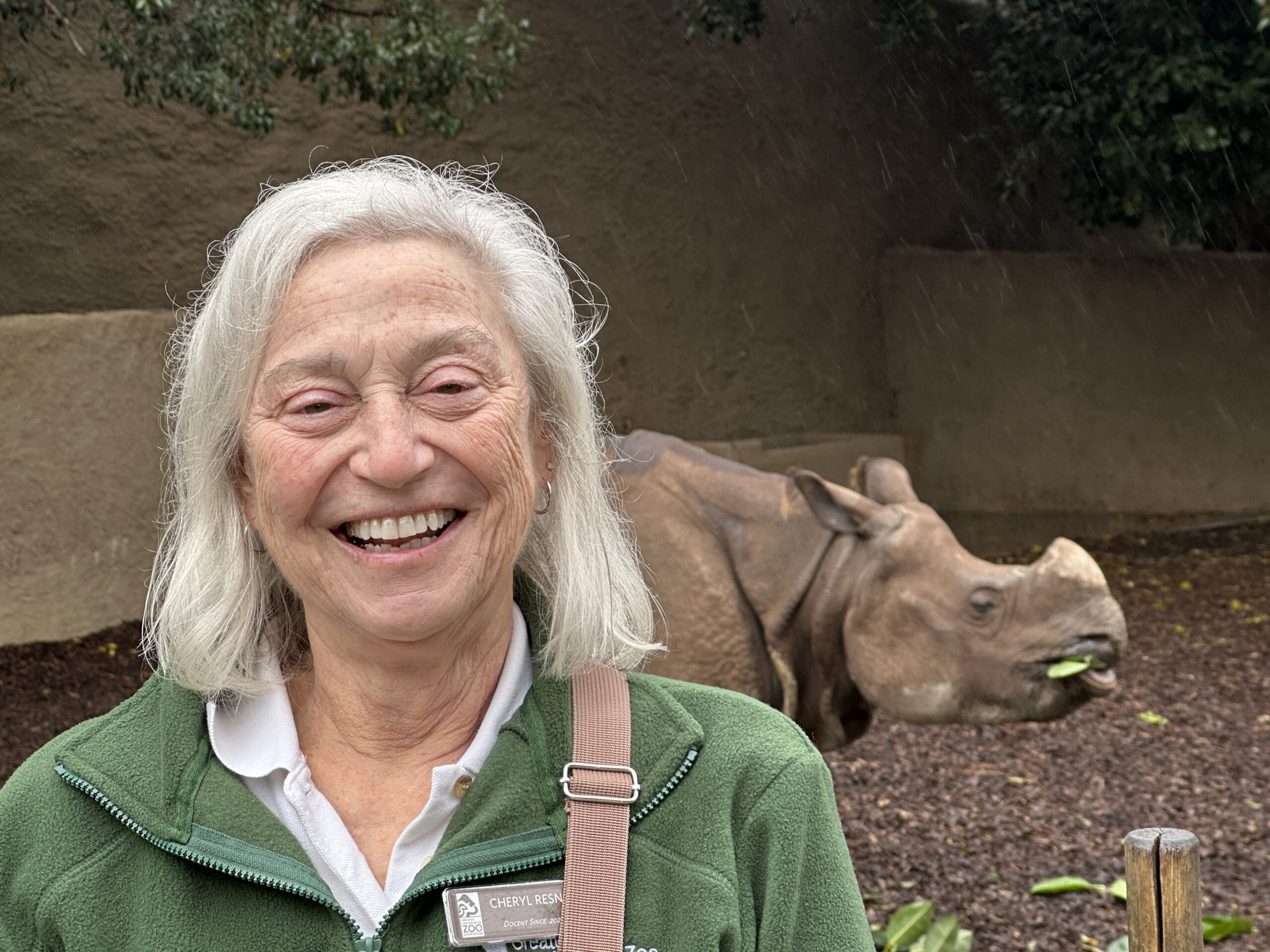 Cheryl Resnik at Zoo with rhino behind her