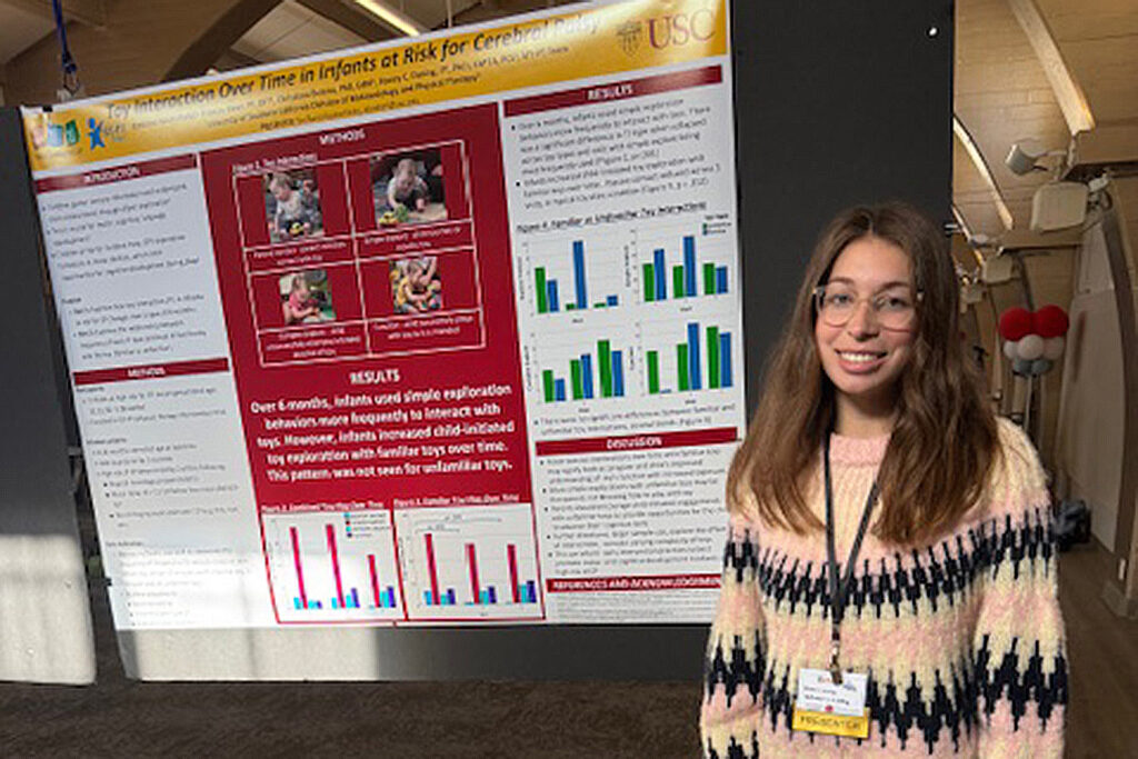 Emi Kosterlitzky standing in front of of her research poster 