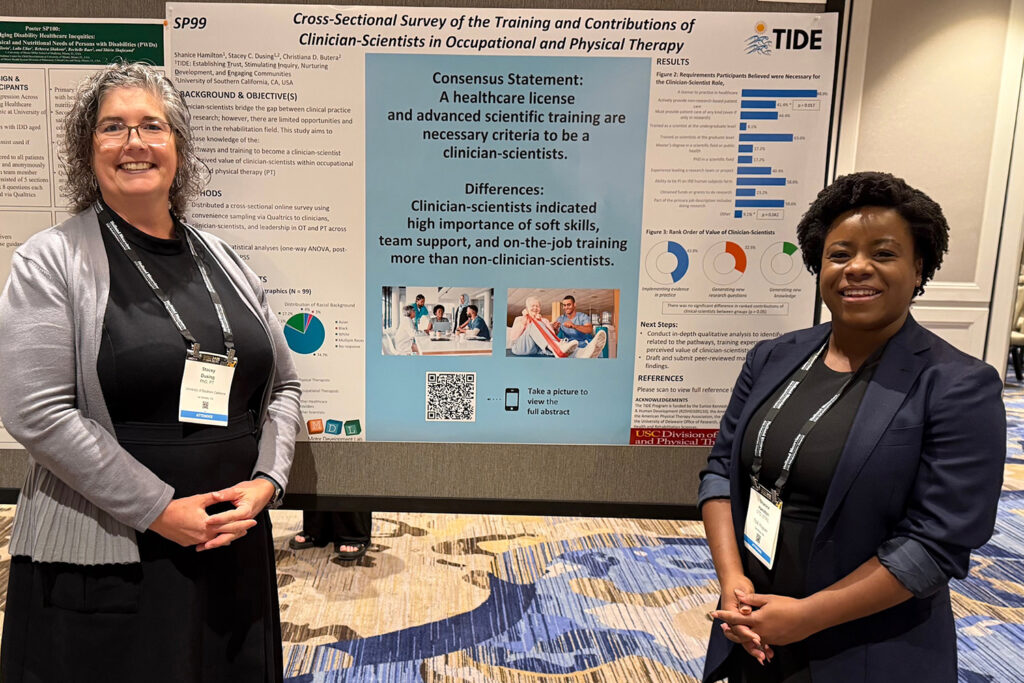 Shanice Hamilton standing alongside Stacey Dusing in front of a research poster