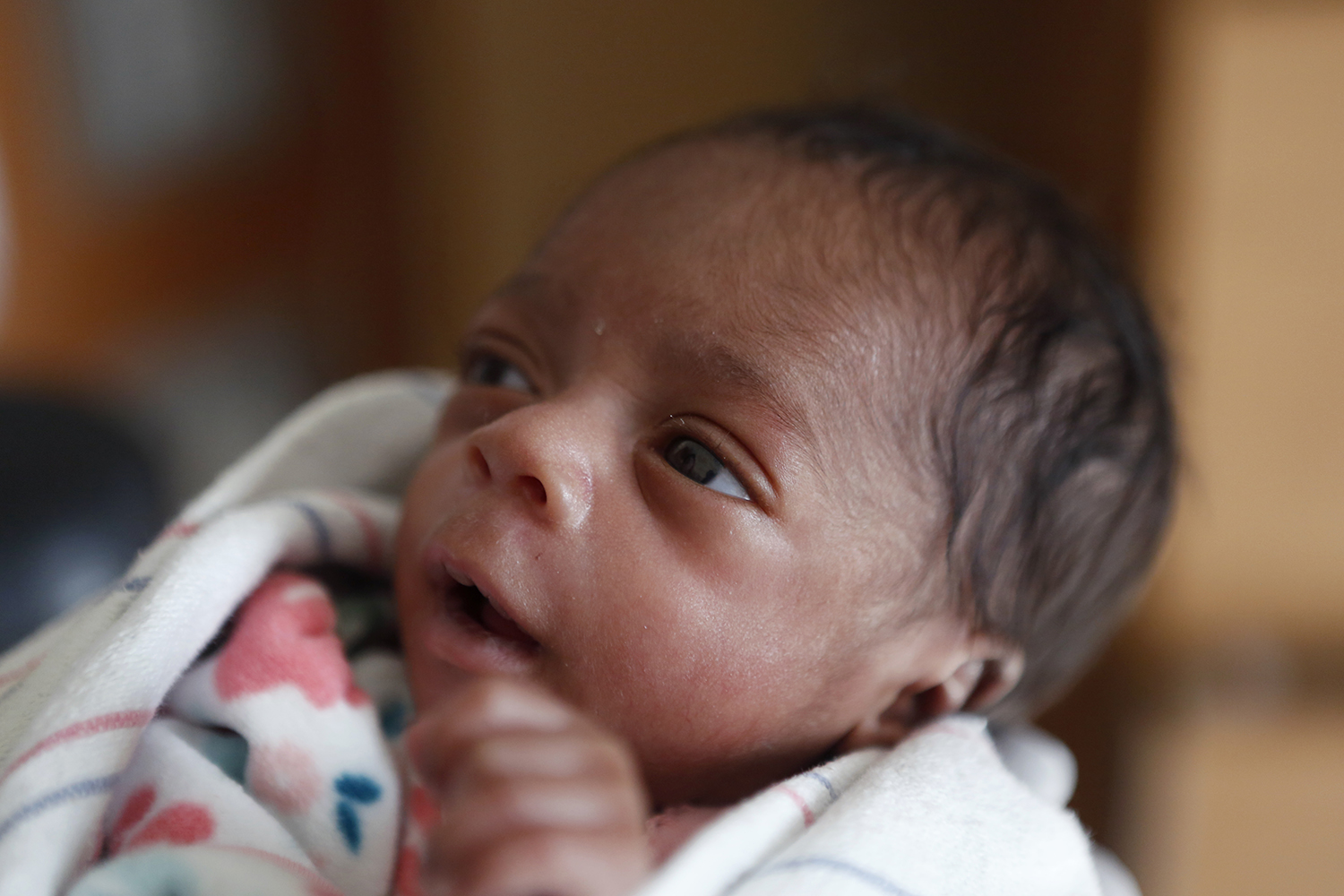 Very premature infant with a fixed gaze on caretaker